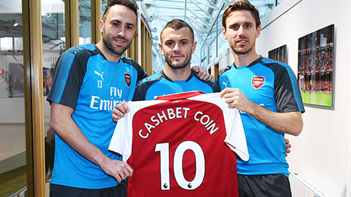 David Ospina, Jack Wilshere, and Nacho Monreal pose with a club shirt as part of the announcement.