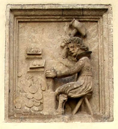 A wall relief showing old coins being hammered.