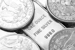 one ounce silver bar surrounded by silver coins